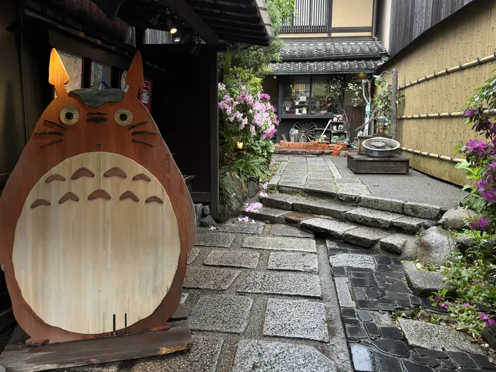 Wooden Totoro cut-out in a stone lane