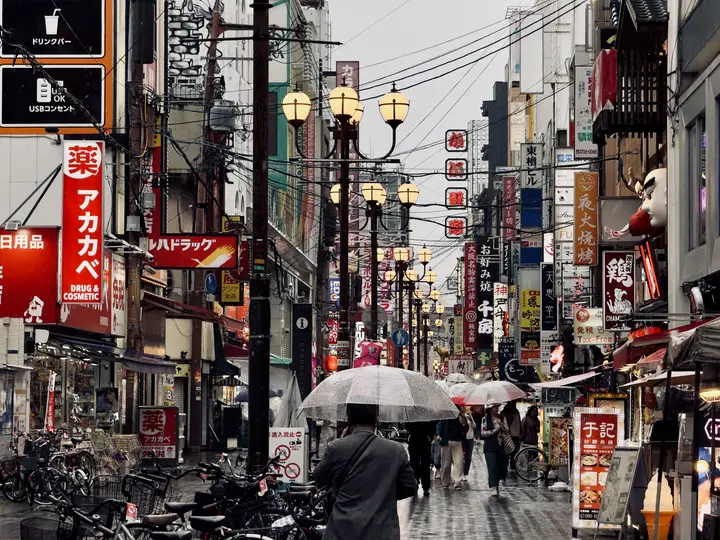 Umbrellas and shop signs on a wet street