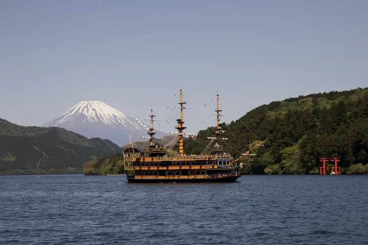 Mount Fuji over a lake with a sailing ship